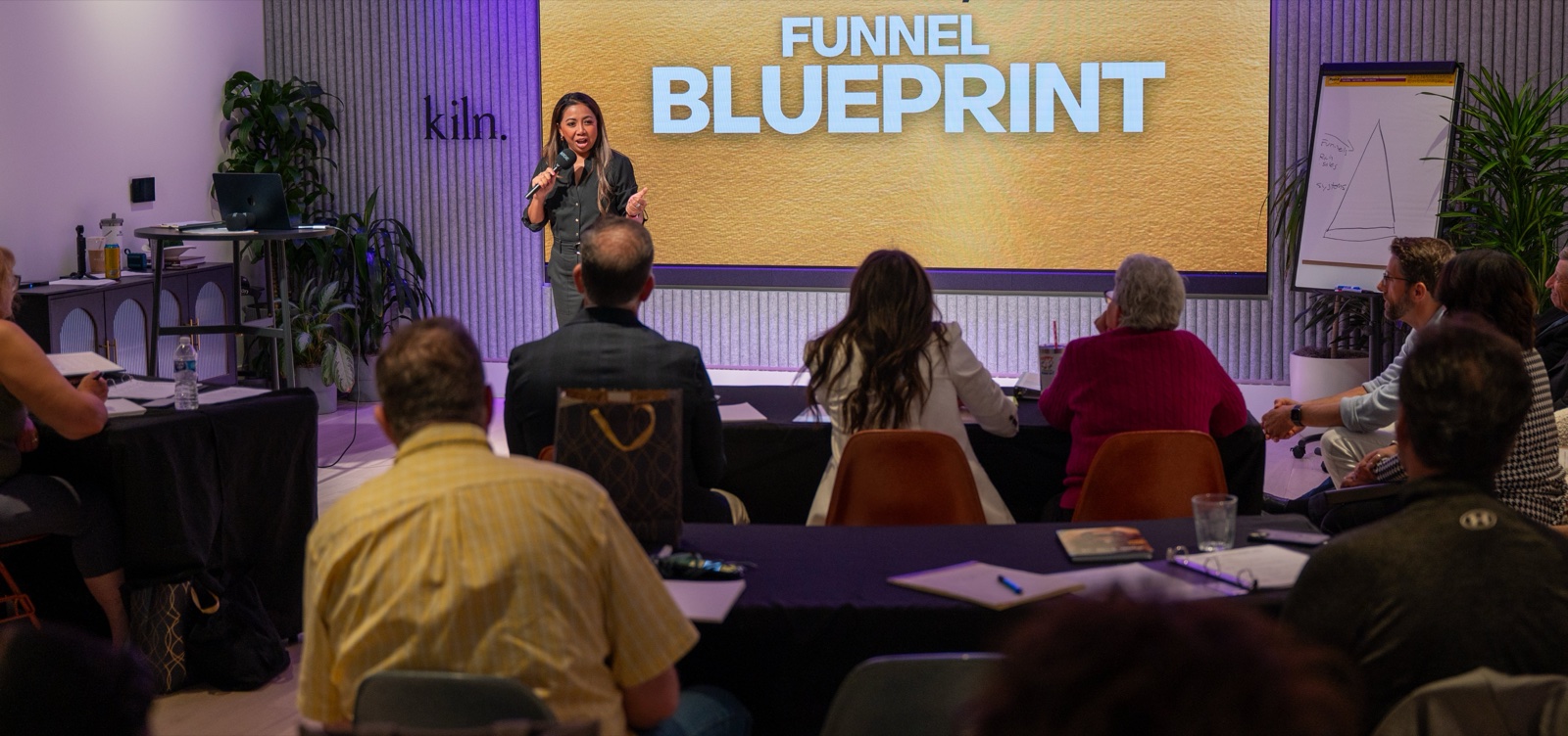 Nim Stant presenting The Six Figure/Month Funnel Blueprint to a live audience